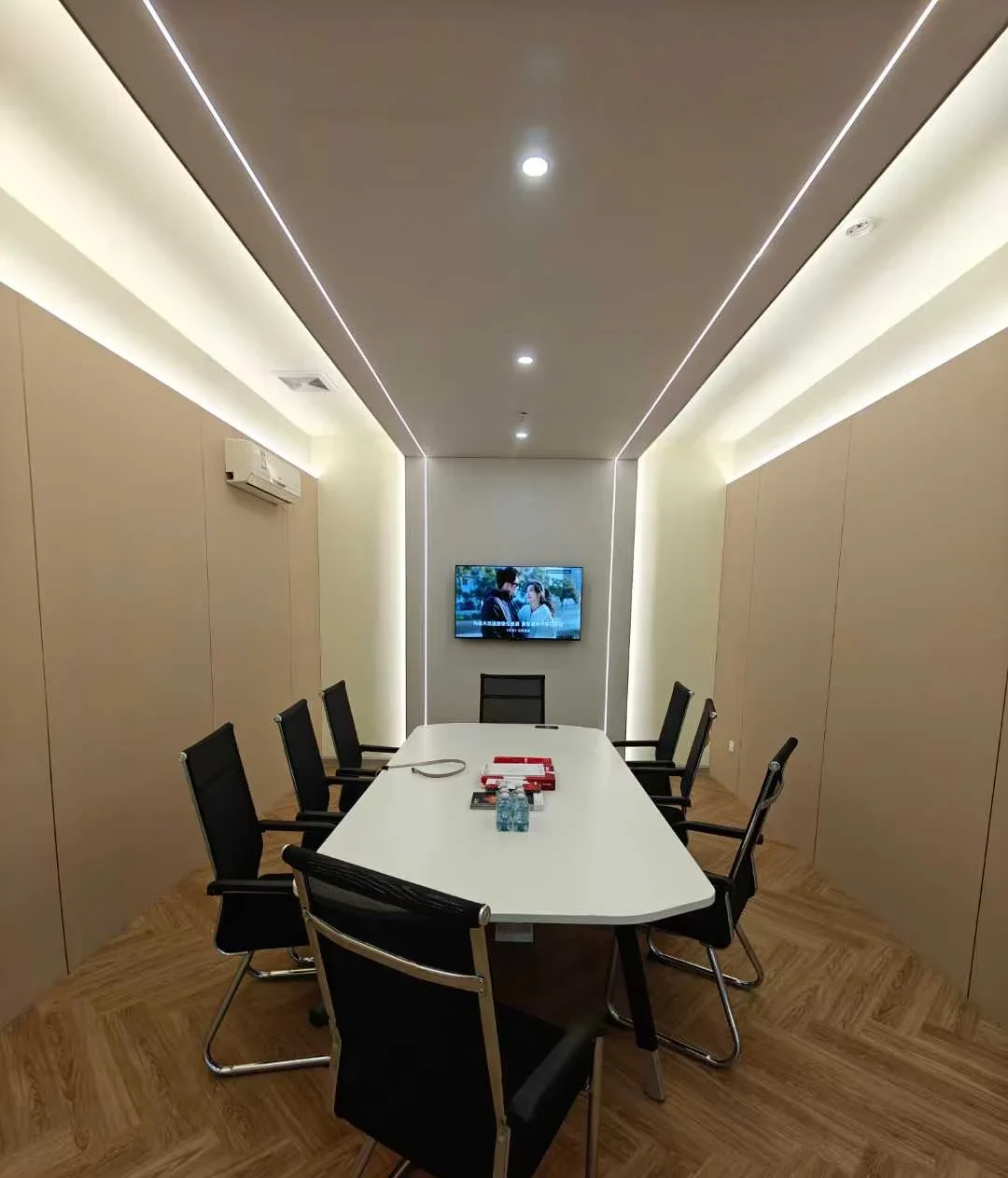 Meeting room with beige wall panels and curved ceiling light coves